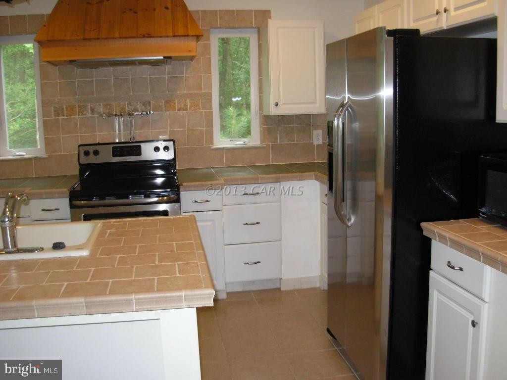 9409 Croppers Island Road Newark, MD 21841 - Photo 13 of 27 a kitchen with a refrigerator and a stove