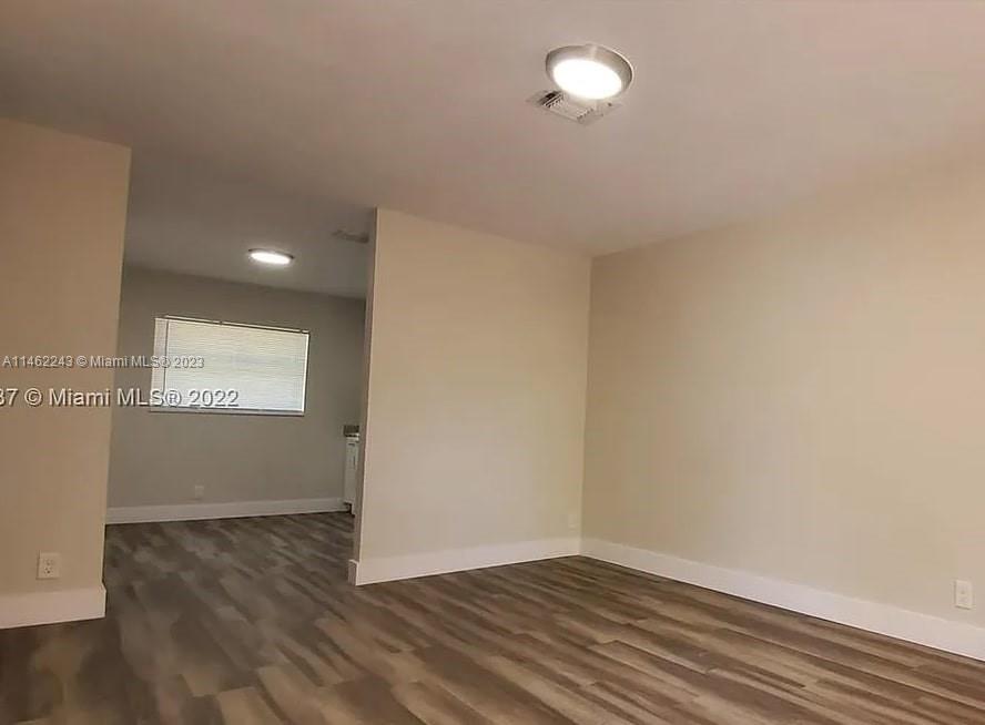 450 Southwest 2nd Street, Unit 4 Pompano Beach, FL 33060 - Photo 6 of 9 a view of an empty room with wooden floor and a window