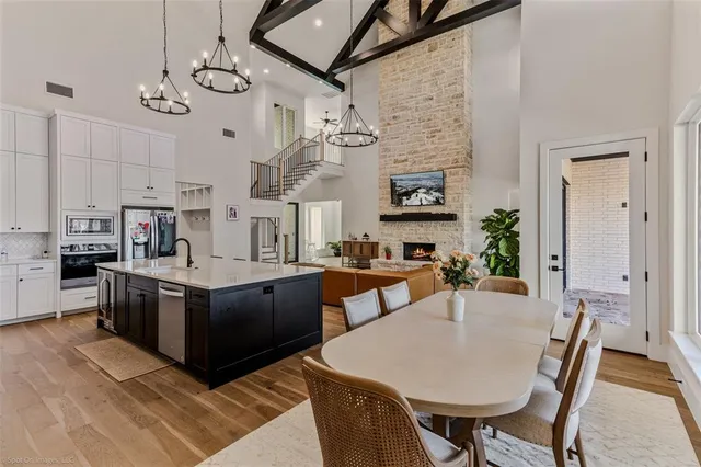 a kitchen with stainless steel appliances granite countertop a stove a sink dishwasher and a refrigerator with wooden floor