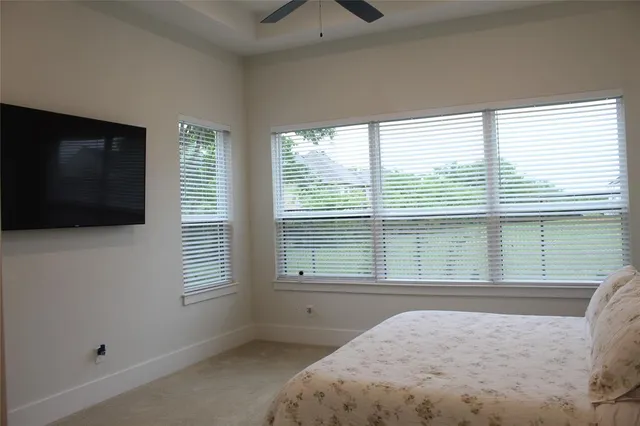 a bedroom with a bed and a flat tv screen on the dresser