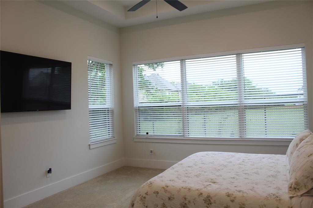 7 Center Court Heath, TX 75032 - Photo 14 of 37 a bedroom with a bed and a flat tv screen on the dresser