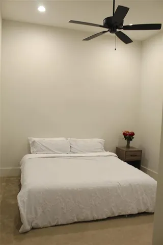 a bedroom with a bed and a ceiling fan