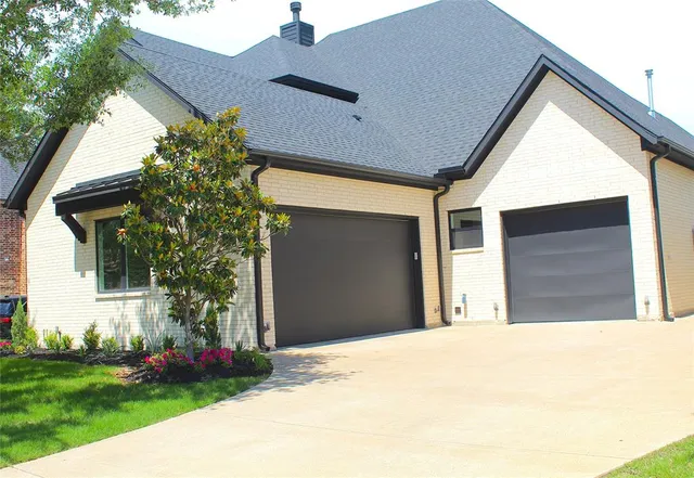 a view of a house with a yard and potted plants