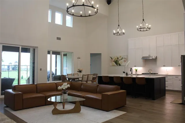 a living room with furniture kitchen and a large window