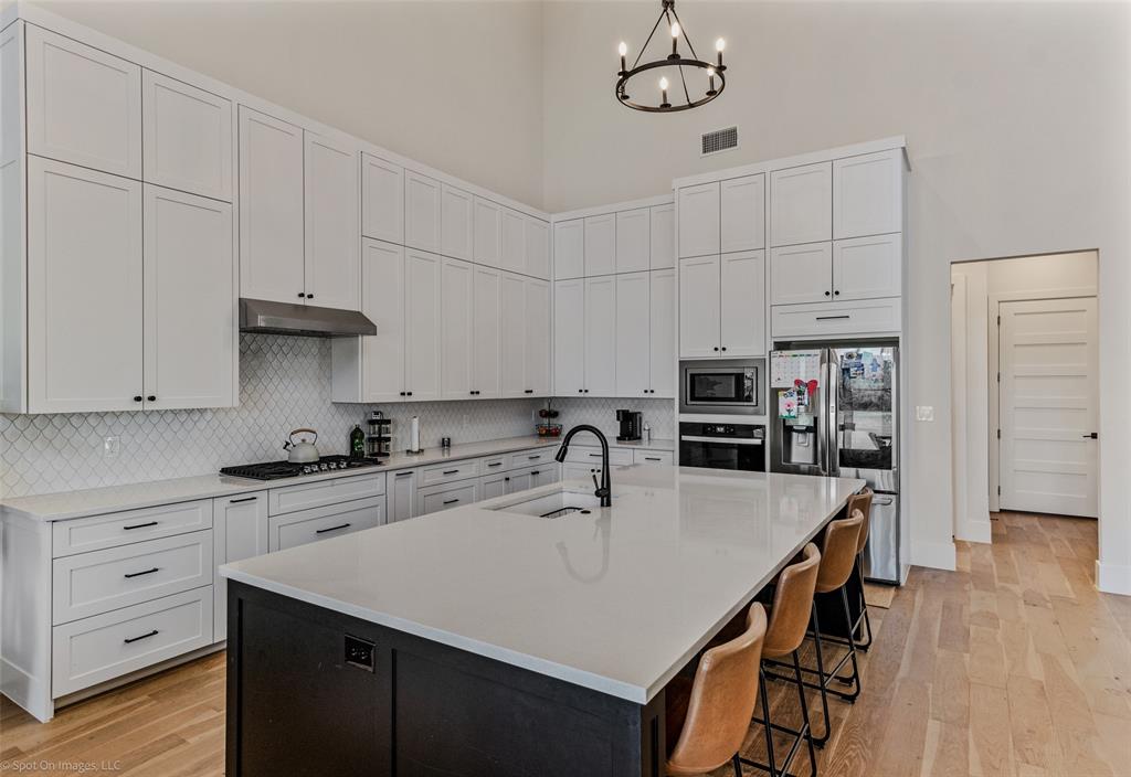 7 Center Court Heath, TX 75032 - Photo 8 of 37 a kitchen with stainless steel appliances a sink a stove a refrigerator and cabinets
