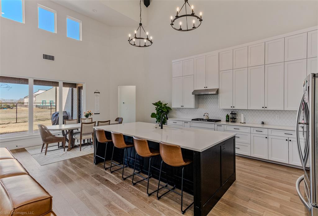 7 Center Court Heath, TX 75032 - Photo 9 of 37 a open kitchen with a dining table chairs and white cabinets