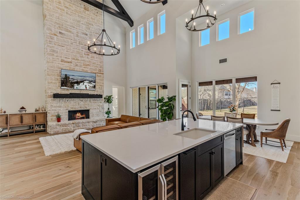 7 Center Court Heath, TX 75032 - Photo 10 of 37 a kitchen with a stove a kitchen island a dining table and chairs with wooden floor