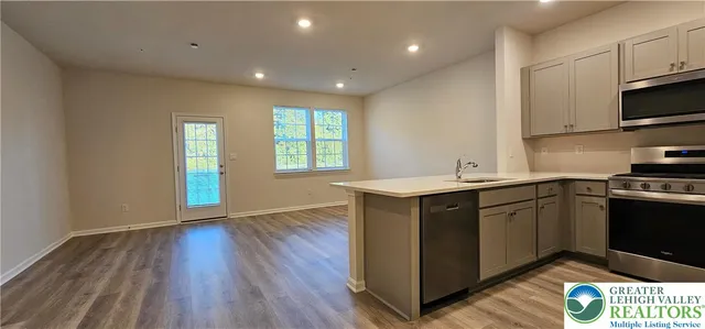 a kitchen with sink cabinets and wooden floor