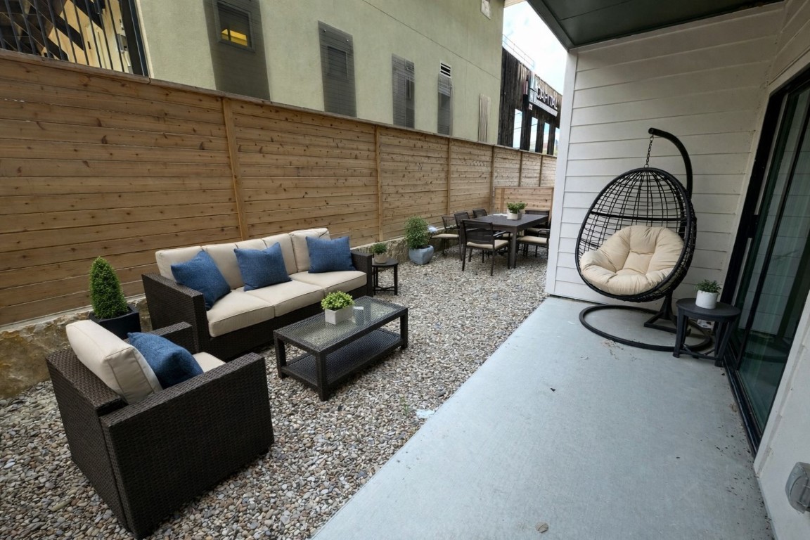 4802 South Congress Avenue, Unit 118 Austin, TX 78745 - Photo 10 of 20 a living room with couches a mirror and a dining table with wooden floor