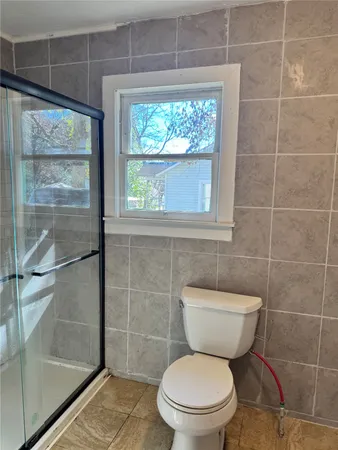a white toilet sitting next to a window
