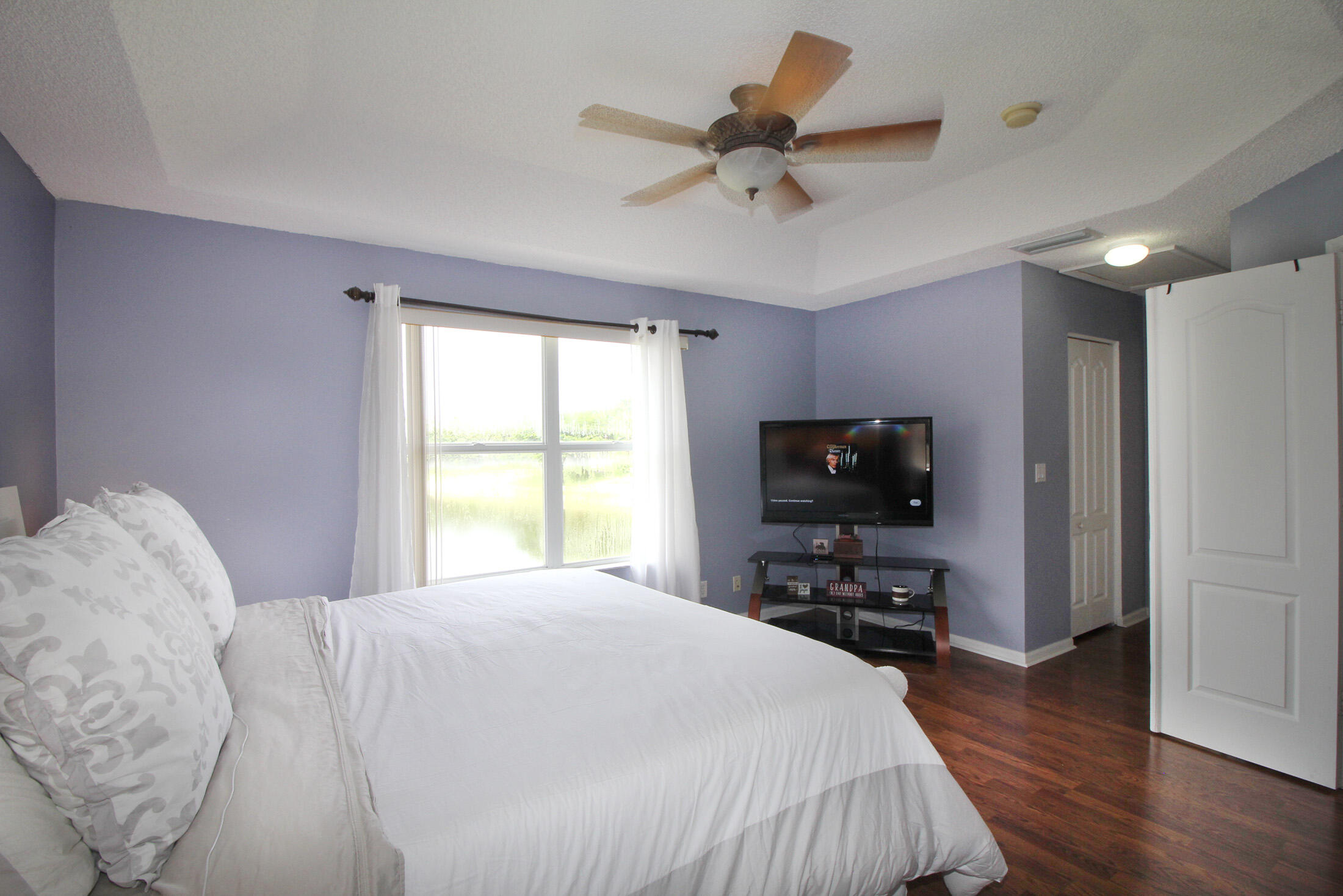 5809 Raceway Road Lake Worth, FL 33449 - Photo 11 of 13 a bedroom with a bed and a flat tv screen on a dresser