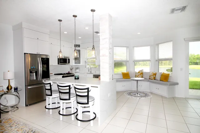 a living room with furniture a fireplace and large windows