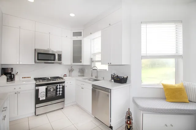 a kitchen with stainless steel appliances a stove a sink and a microwave