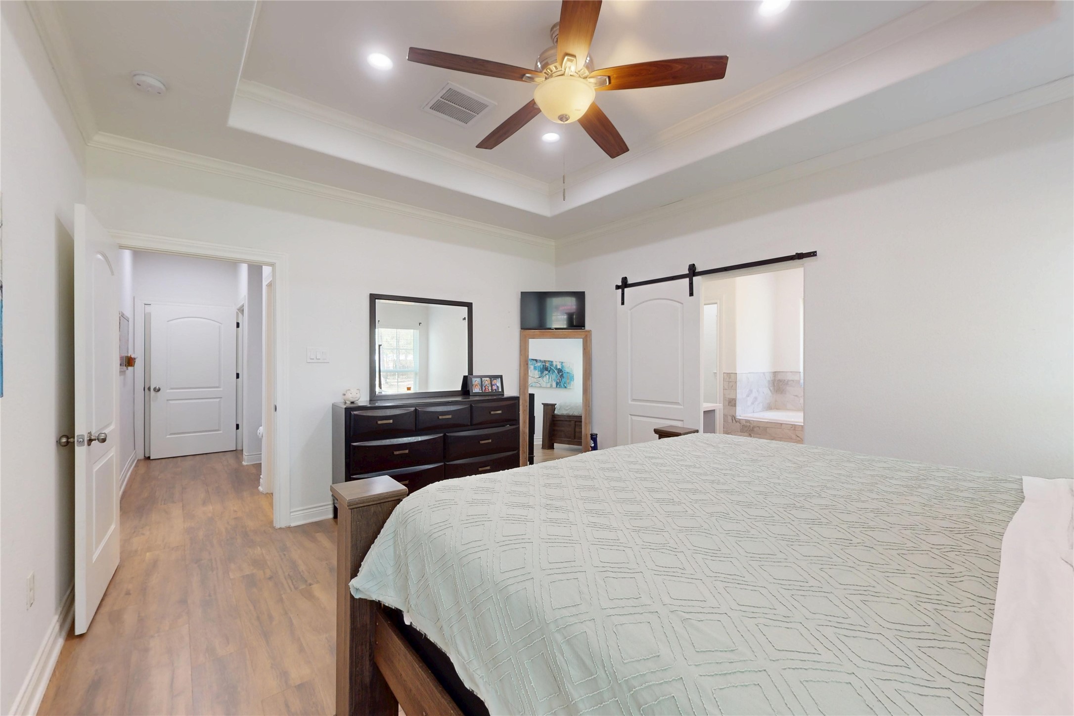 7815 Timber Switch Road Cleveland, TX 77328 - Photo 29 of 40 a bedroom with a bed and a chandelier