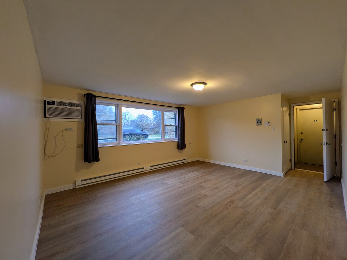 11840 South Karlov Avenue, Unit BE Alsip, IL 60803 - Photo 2 of 10 an empty room with wooden floor and windows