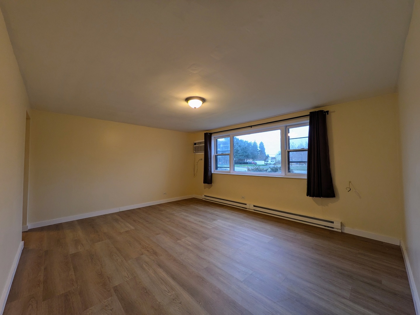 11840 South Karlov Avenue, Unit BE Alsip, IL 60803 - Photo 3 of 10 an empty room with wooden floor and windows