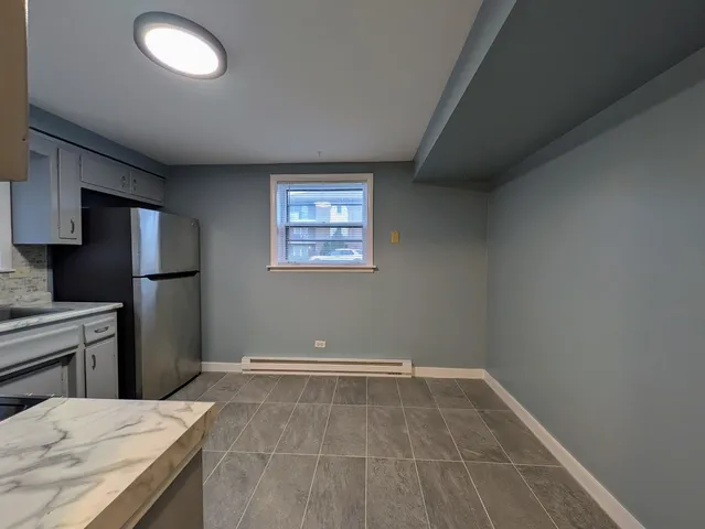 a room with a bed and a refrigerator