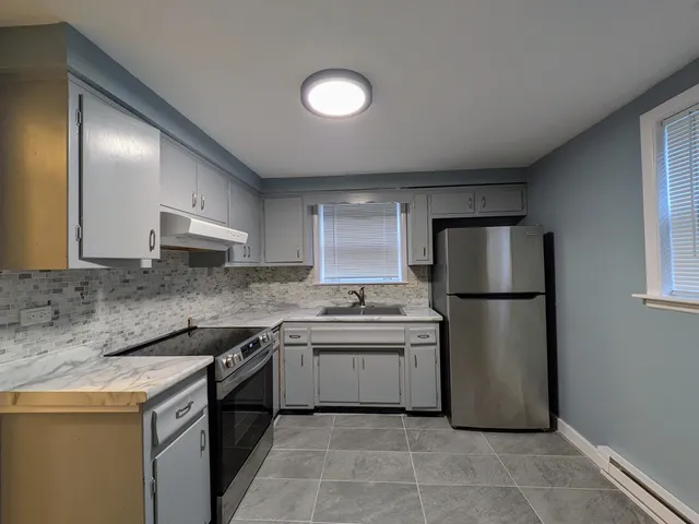 a kitchen with a sink a refrigerator and a stove