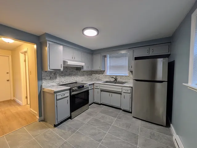 a kitchen with stainless steel appliances granite countertop a refrigerator sink and stove