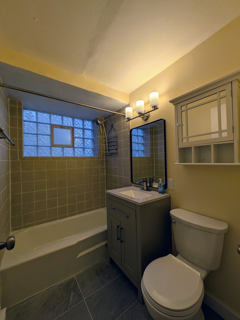 11840 South Karlov Avenue, Unit BE Alsip, IL 60803 - Photo 7 of 10 a bathroom with a sink a toilet and shower