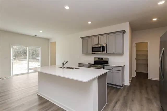 a kitchen with a sink a microwave a refrigerator and cabinets