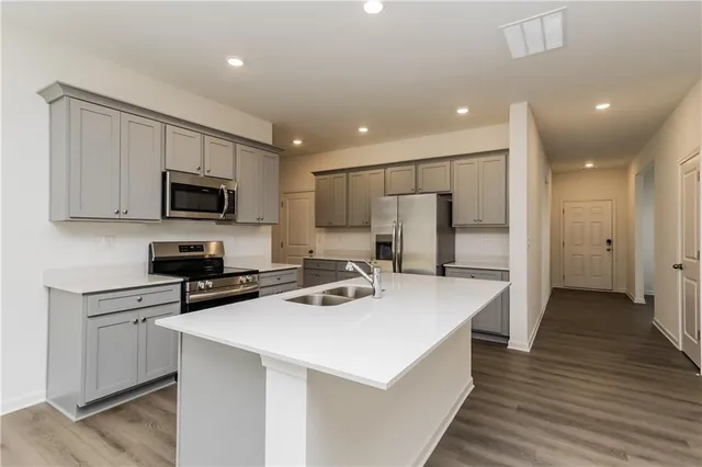 a kitchen that has a lot of cabinets and wooden floor