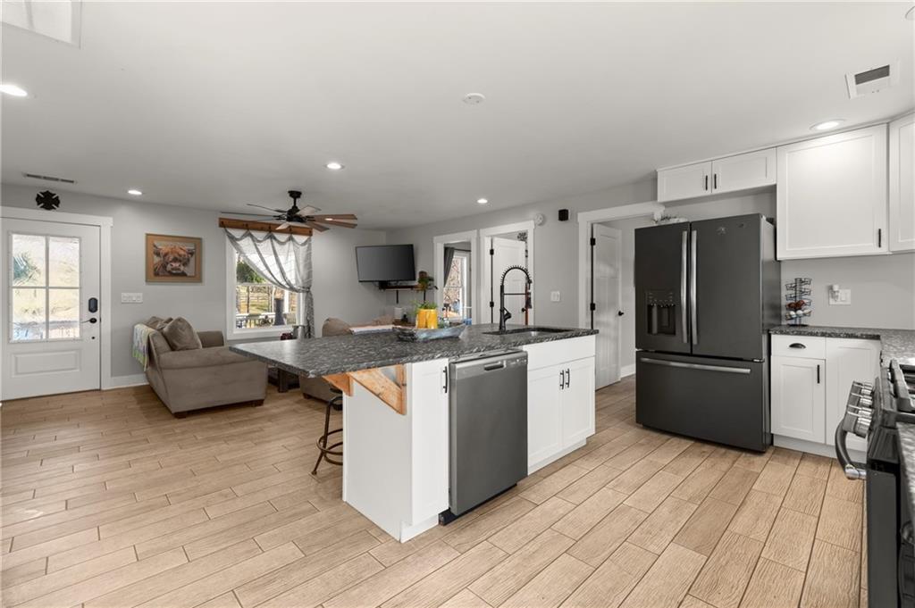 38 Hightower Road Talking Rock, GA 30175 - Photo 10 of 48 a kitchen with stainless steel appliances a stove a refrigerator a sink dishwasher and a oven with wooden floor