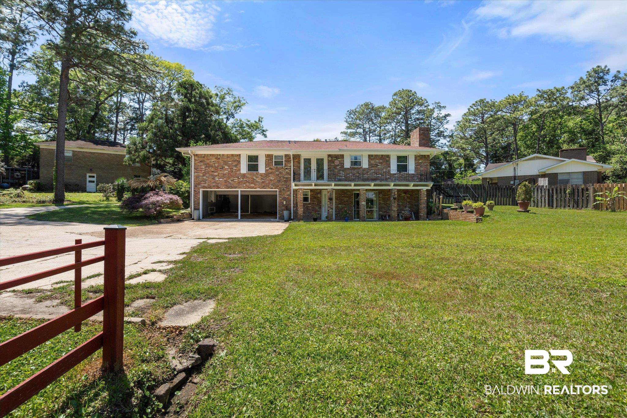 706 Sutherland Drive Chickasaw, AL 36611 - Photo 28 of 33 Back of house featuring a chimney, fence, concrete driveway, brick siding, and a garage