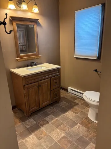 a bathroom with a sink a toilet and mirror