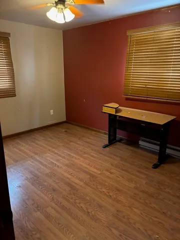 a room with wooden floor and windows