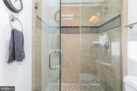 a bathroom with a granite countertop sink and a mirror with toilet