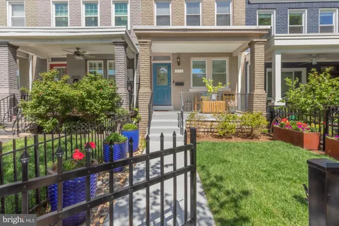 front view of a house with a yard and potted plants