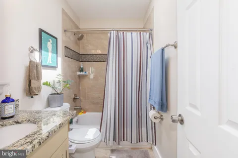 a living room with stainless steel appliances furniture a rug and a window