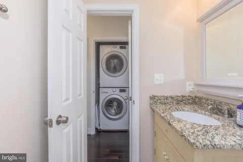a view of cabinets a sink wooden floor and a potted plant