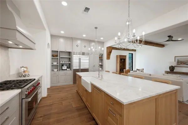 a large kitchen with kitchen island a stove a sink a refrigerator and a counter space