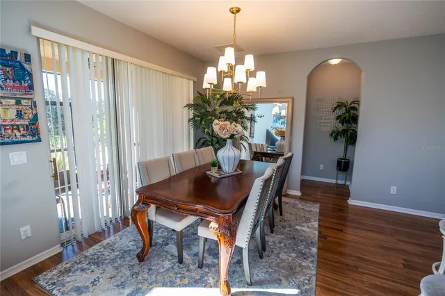 a dining room with furniture potted plants and wooden floor