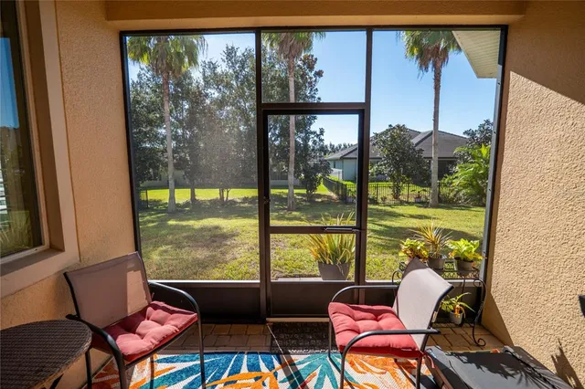 a living room with patio chairs and a floor to ceiling window