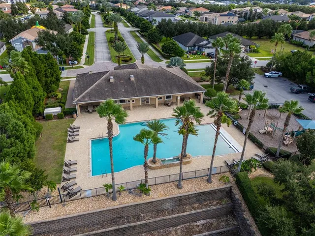 an aerial view of a tennis ground and a cars park side of the road