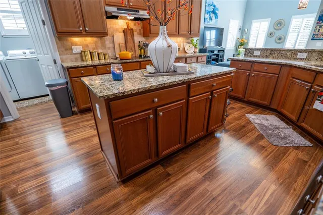 a kitchen with stainless steel appliances granite countertop wooden floors and sink