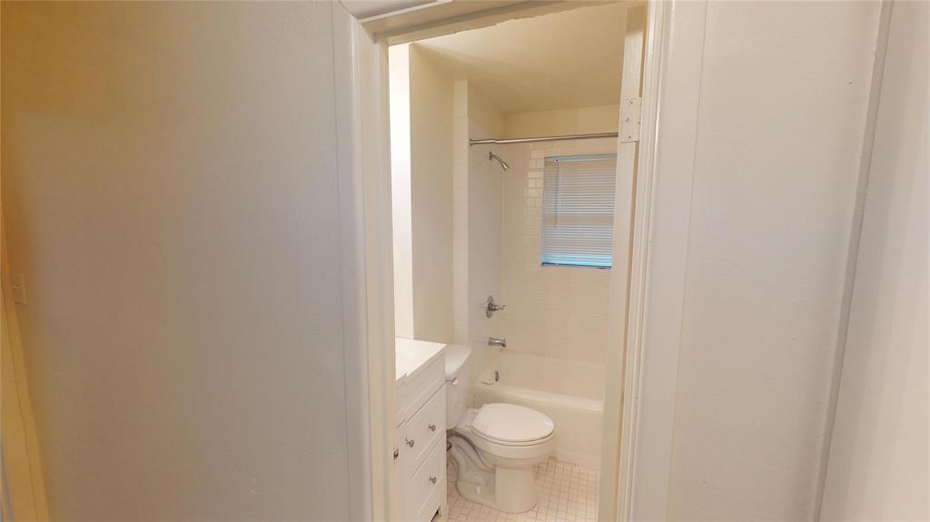 1705 Crescent Street Denton, TX 76201 - Photo 7 of 7 a bathroom with a granite countertop toilet and a sink