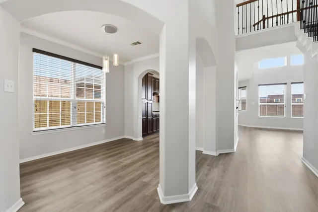 a view of an empty room with window and wooden floor