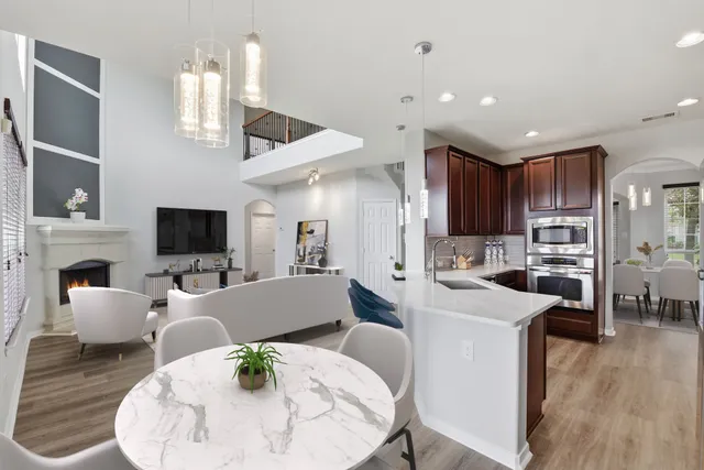 a living room with stainless steel appliances kitchen island granite countertop furniture a fireplace and a flat screen tv