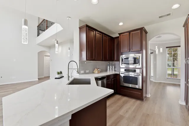 a kitchen with stainless steel appliances granite countertop a refrigerator and a stove top oven