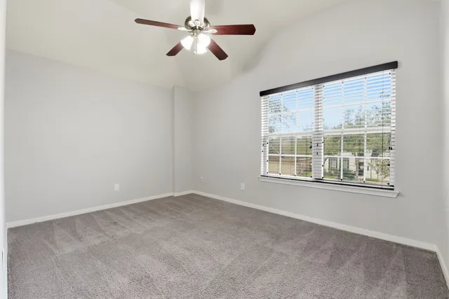 an empty room with a window and a fan