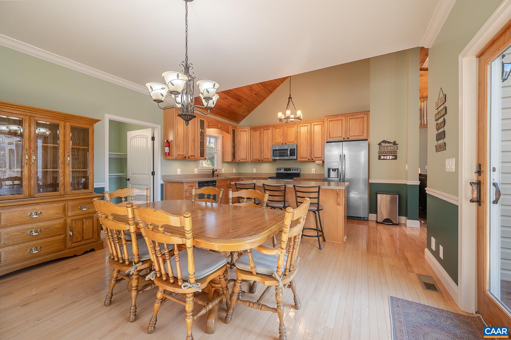 909 Gap Bridge Road Moneta, VA 24121 - Photo 34 of 75 a dining room with stainless steel appliances kitchen island granite countertop a table chairs and a refrigerator