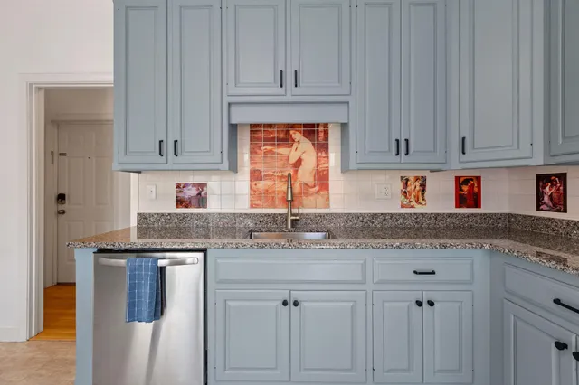 a kitchen with stainless steel appliances granite countertop a refrigerator a stove and a sink with wooden floor