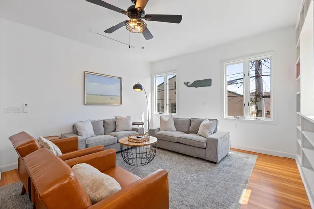 a living room with furniture wooden floor and a window