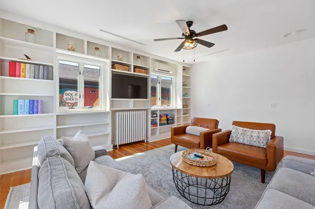 a living room with furniture a ceiling fan and a window