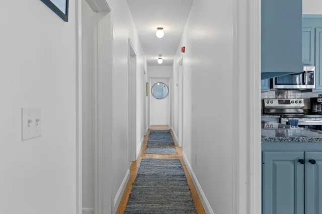 a view of a hallway with wooden floor