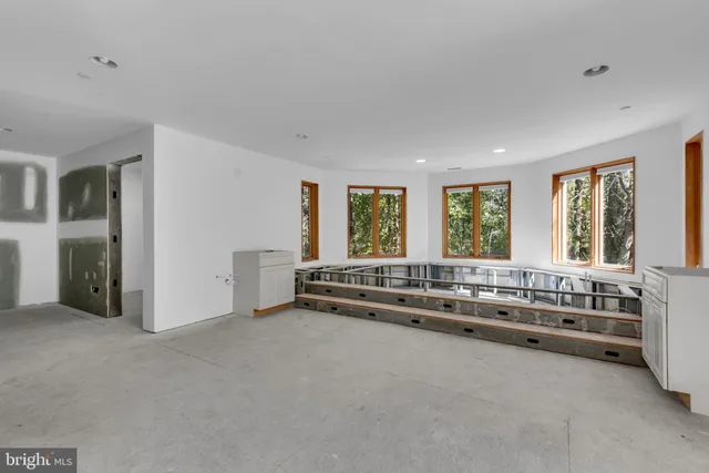 a large white bed sitting in a room next to a window
